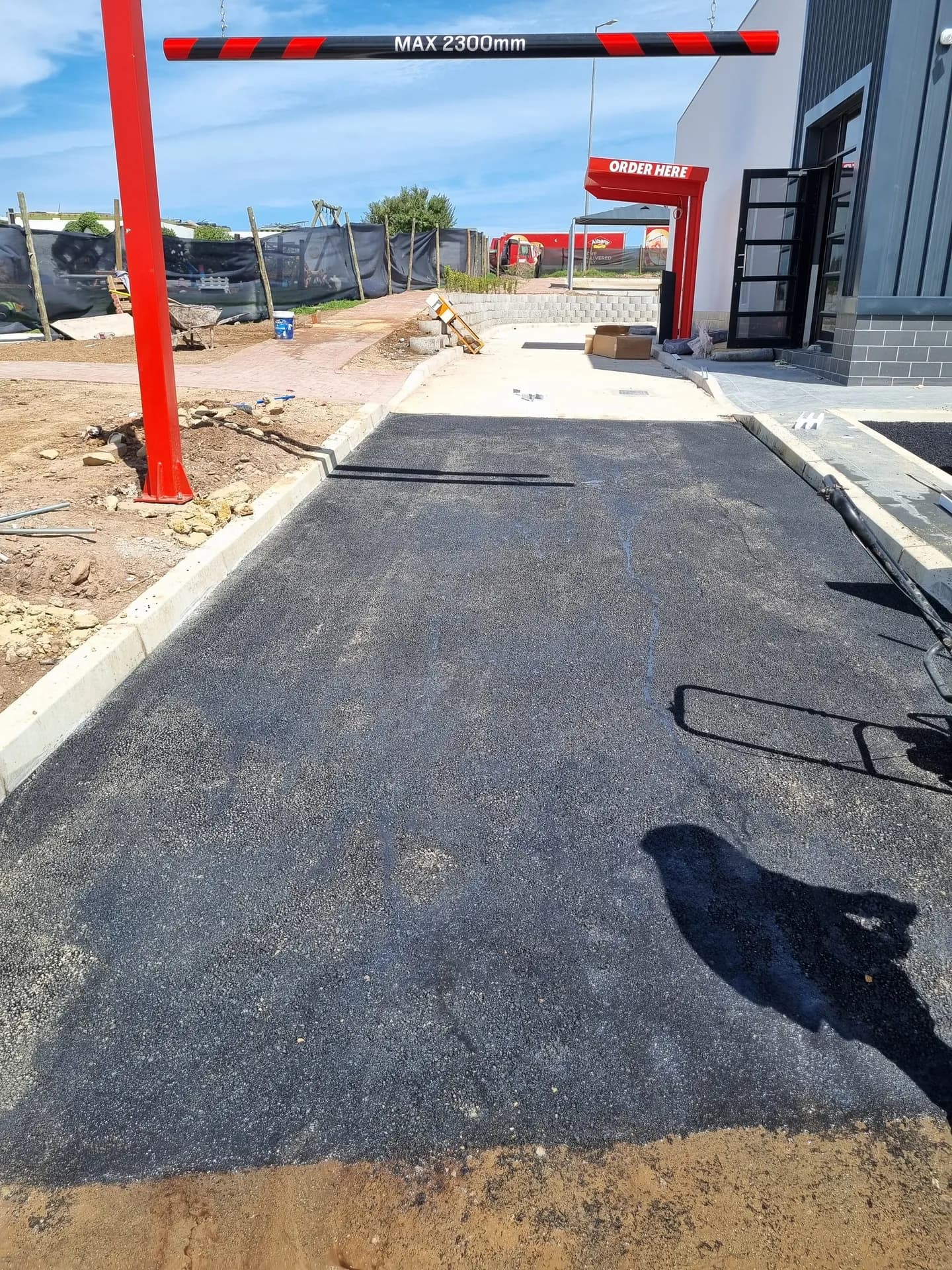 New asphalt access with concrete kerbs at a commercial site