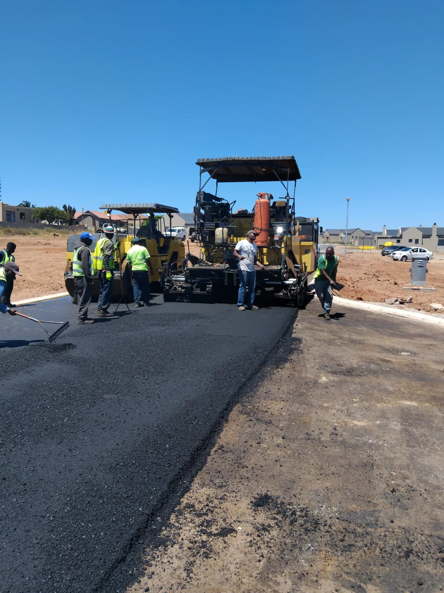 Paving crew at work behind the asphalt paver
