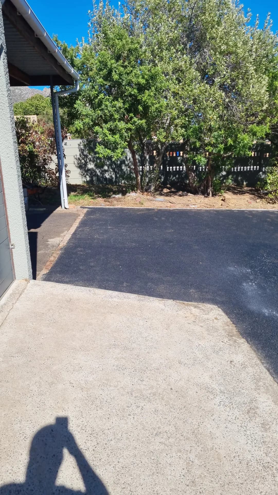 New asphalt driveway beside a house
